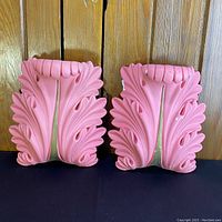 Pair of wall pocket vase sconces in pink and gold chalkware, showing detailed leaf pattern and scalloped top edge.