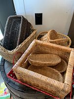 Top view of various wicker and rattan baskets stacked inside each other on a wooden table.