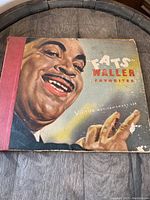 Front cover of the vintage album featuring a colored painted portrait of Fats Waller with the text 'Fats Waller Favorites' on the front. The cover shows wear and discoloration.