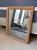 Full view of the vintage mirror showing the gold carved frame and reflective surface.