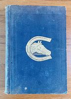 Front cover showing blue cloth binding, gilt horse head in horseshoe motif and blind-stamped decoration