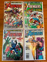 Four Avengers comic books placed on a wooden surface showing front covers of issues #204, #207, #209, and #223