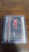Front side of LeBron James rookie card in protective case, showing him in action.