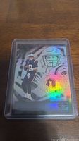Front of Mac Jones rookie trading card showing player image with holographic effect.