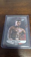 Front of Mike Tyson trading card in plastic protective case showing image of young fighter and 1st edition badge.