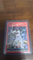 Front of 1990 Donruss Sammy Sosa rookie card with photo and red border