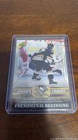 Front of the Sidney Crosby rookie hockey card showing action photo and card title.