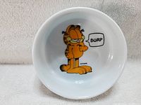Top-down view inside the bowl showing Garfield the Cat graphic with 'BURP' speech bubble.