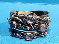 Close-up of the front of the adjustable silver ring displaying the four lilac amethyst stones and swirl pattern.