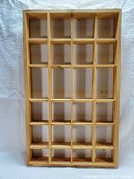 Top-down photo of the wooden display shelf showing the entire structure and the grid arrangement of compartments.