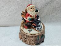 Santa figurine on toy train, front and top view showing detailed painting and design.