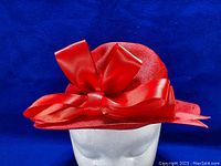 Front view showcasing the large red satin ribbon bow and textured georgette fabric of the red ladies tilt hat.