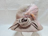 Side angle of the vintage wool cloche hat showing feather detail and knot