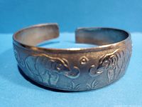 Close-up of the bracelet showing elephant engravings and textured background