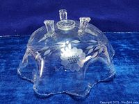 Top side view showing ruffled edges and etched floral patterns of the clear glass bowl.