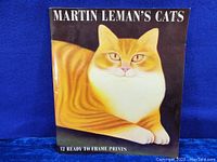 Front cover of the book showing a large cat painting and title Martin Leman's Cats with note of 12 ready to frame prints.