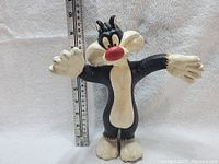 Front view of Sylvester the Cat figure showing full height against a ruler, approximately 8.5 inches tall.
