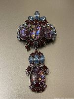 Full view of Joan Rivers signed chandelier brooch with purple amethyst cabochons and light blue/navette stones on silver-tone setting