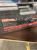 Close-up of the black plastic carrying case with Craftsman label indicating 2 1/4 ton capacity and lift range of 4-1/2 to 14-1/2 inches.