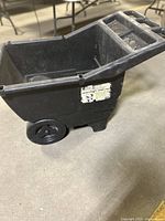 Side view of black Handy Hauler garden cart showing the integrated handle and wheel design.