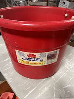 Front view of large red heavy duty all-purpose tub with label including brand and guarantee.