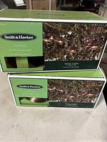Two green boxes of Smith & Hawken string lights stacked, showing brand, contents, and packaging.