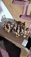 Group image of approximately 20 wooden animal napkin rings displayed on a wooden table, showing various animal shapes and wood tones.