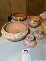 Photo showing large pink Canada Pottery bowl with white grapevine relief, Roseville plant pot and dish, and two candle holders.
