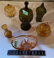 Photo showing all six art glass pieces including four lidded containers, one vase, and one art glass bowl with an 8-inch ruler for scale.