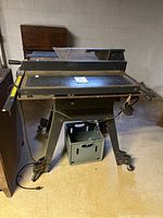Full view of Craftsman electric table saw showing the work surface, supporting frame with wheels, and power cord.