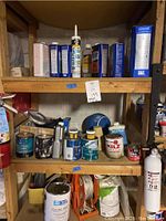Shelves with various solvents, small paint cans, sealants, and painting accessories