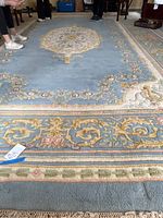 Full view of rug showing central medallion and border with feet for scale