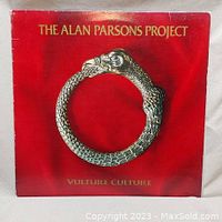 Front cover of 'Vulture Culture' vinyl LP by The Alan Parsons Project with ouroboros artwork on red background.