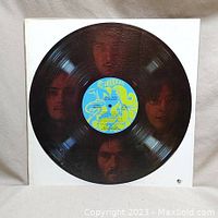Vinyl record with colorful Columbia label and band member faces visible underneath the vinyl.