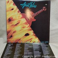Front cover of April Wine Walking Through Fire album showing guitar in flames and band name.