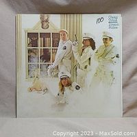 Front cover of the Cheap Trick Dream Police vinyl album showing band members in white uniforms and a surreal background.