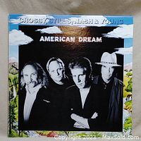 Front cover of the vinyl LP 'American Dream' by Crosby, Stills, Nash & Young showing band members portrait on scenic painted background.