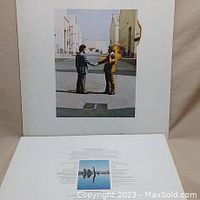 Front cover of Pink Floyd Wish You Were Here album depicting two men shaking hands, one on fire.