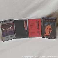 Four cassette tapes displayed upright including Ringo Starr, John Lennon Menlove Ave, and two George Harrison live tapes.