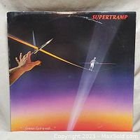 Front cover of Supertramp Famous Last Words vinyl album showing sunset artwork with hand holding a knife and tightrope walker.