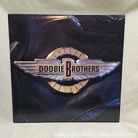 Front cover of The Doobie Brothers 'Cycles' vinyl album showing metallic band logo on dark background