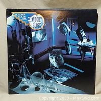Front cover of The Moody Blues vinyl album The Other Side of Life with artistic photo montage and title logo.