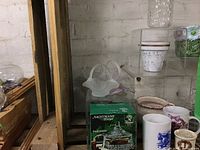 Wide view of crystal and glass decorations including Nachtmann box, glass baskets, mugs, and stained glass bird, set against a backdrop of shelves.