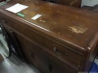 Top view of vintage wood dresser showing surface scratches and wear on top finish.