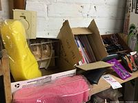 Box of personal care items, including yellow and pink bath sponges, and angel-shaped soaps