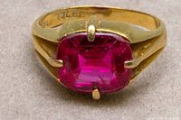 Front view of ring showing faceted cushion-cut ruby and prong setting