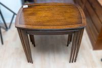 Three wooden nesting tables stacked together viewed top-down showing the finish and shape.
