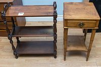 View of both wooden furniture pieces: a dark three-shelf bookshelf and a lighter telephone table with drawer and shelf