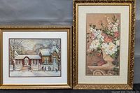 Two ornately framed prints by Trisha Romance; one winter schoolhouse scene and one floral arrangement print.