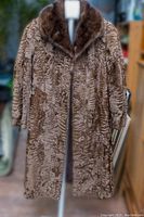 Front view of the vintage long fur coat highlighting the texture and length with the baby calves fur body and mink fur collar.